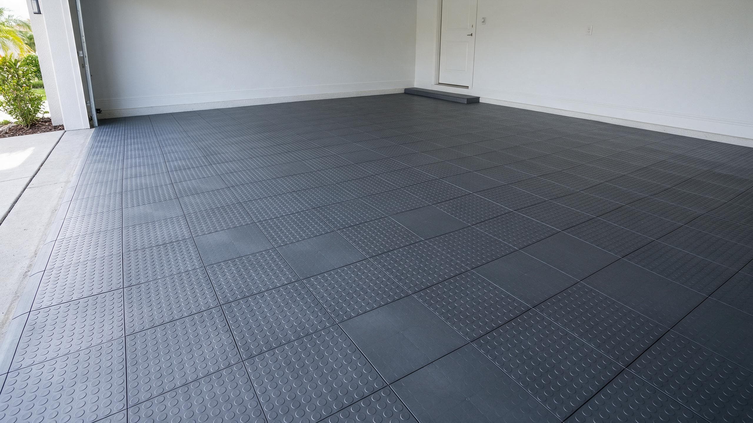 Graphite interlocking polymer garage tiles installed over a residential slab.