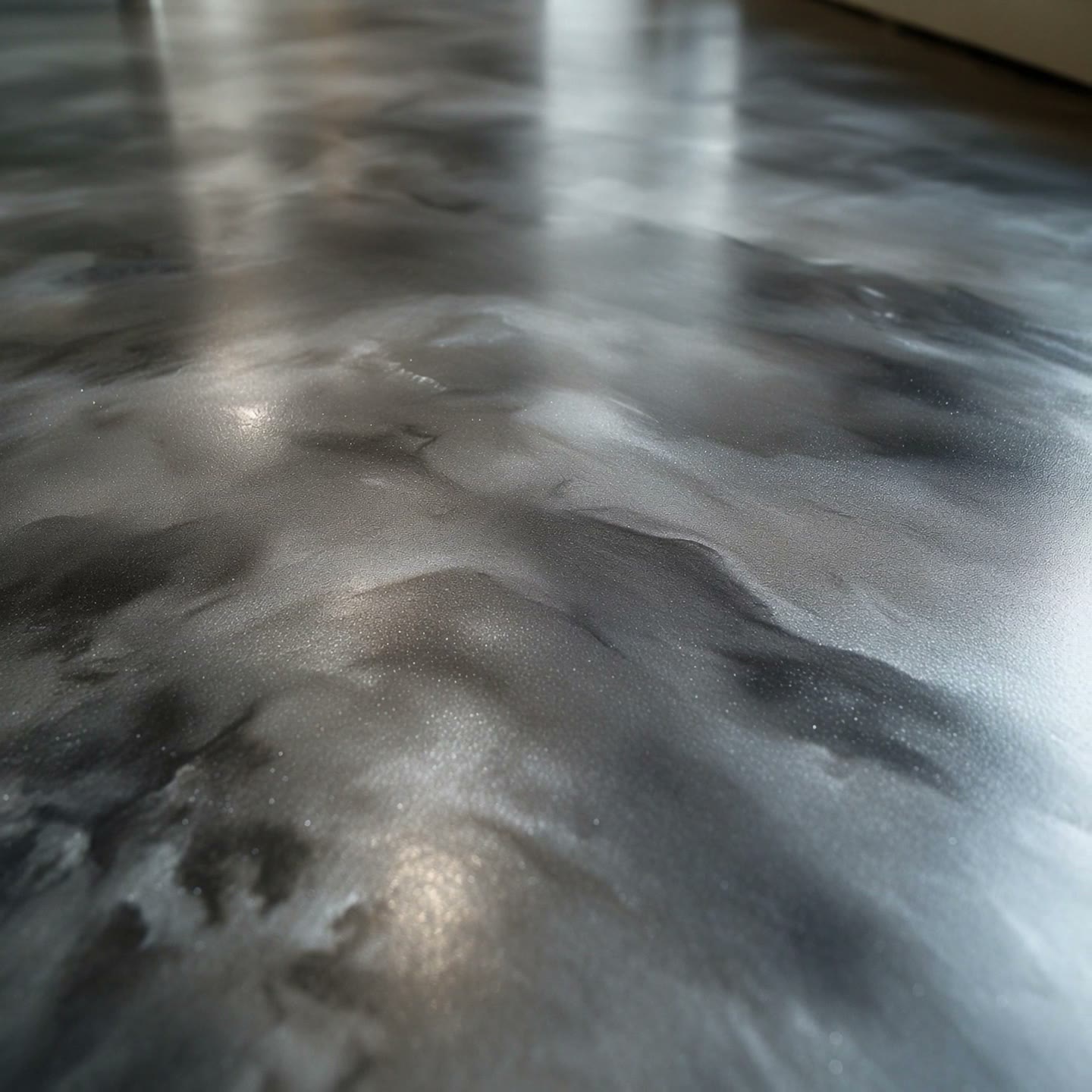 Macro of a marbled silver and charcoal metallic epoxy floor.